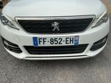 the front of a white car parked in a parking lot