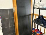 une salle de bains avec des toilettes et une étagère où l'on range des vêtements