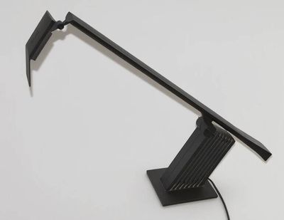 une photo d'une lampe de bureau posée sur une surface blanche