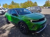 a green suv parked in a parking lot next to other cars