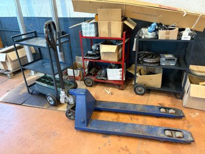 a fork lifter sitting on the floor in front of a pile of boxes