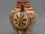 un vase marron orné de motifs sur un fond gris
