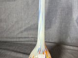 a glass vase that is sitting on a gray cloth