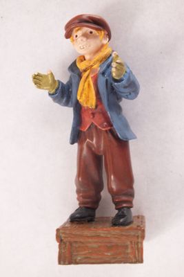 une figurine représentant un homme portant un chapeau et une écharpe