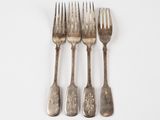 three forks and a knife are sitting on a white surface