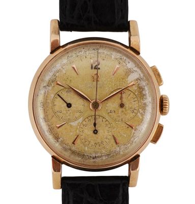 un gros plan d'une montre en or avec un bracelet en cuir noir