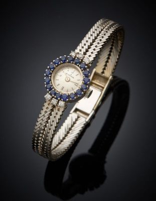 a close up of a wrist watch with blue sapphires on it