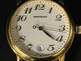 gros plan d'une montre-bracelet en or sur une surface noire