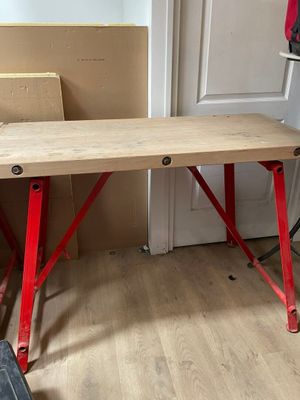 une table en bois aux pieds rouges dans une pièce