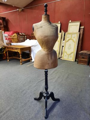 un mannequin en bois posé sur un trépied dans une pièce