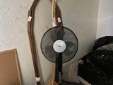 un ventilateur posé à côté d'une chaise dans une pièce
