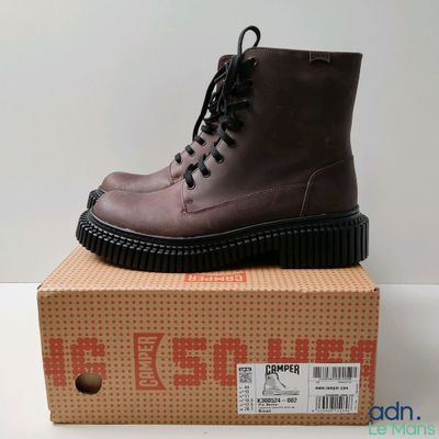 une paire de bottes marron posée sur une boîte