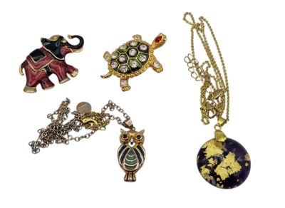 four pieces of jewelry including a turtle, an elephant, and a turtle