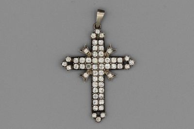 un pendentif en forme de croix sertie de diamants,