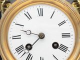 a gold clock with roman numerals on the face