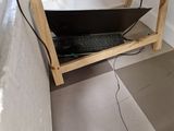 a laptop sitting on a wooden stand in the corner of a room