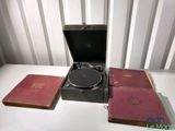 un tourne-disque posé à côté de deux livres et d'un autre tourne-disque