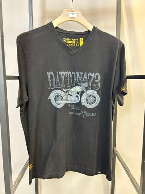 un t-shirt gris suspendu à un portant métallique dans un magasin