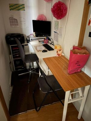 un bureau sur lequel se trouve un ordinateur, dans une petite pièce