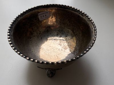 a silver bowl sitting on a table with a tag on it