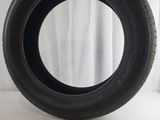 a close up of a tire on a white surface with a curtain behind it