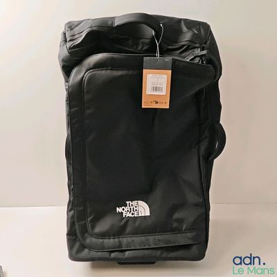 un sac noir muni d'une étiquette, posé sur une table