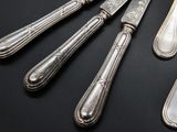 five forks and a knife on a black table