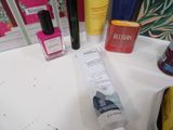 a bottle of nail polish and a tube of lotion sitting on a counter