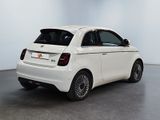 the small white car is parked in a large room