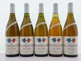 quatre bouteilles de vin sont alignées sur une surface blanche