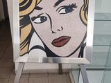 un tableau représentant une femme, exposé sur un socle dans un magasin