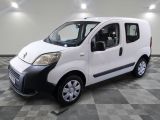la petite camionnette blanche est garée sur un carrelage à carreaux