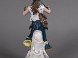 a figurine of a woman with a bird on her shoulder