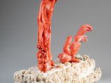 an orange sculpture of a woman and a bird on a piece of coral