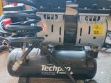 un petit compresseur d'air posé sur une pile d'outils