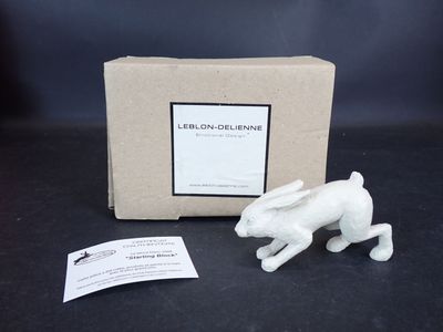 La petite figurine de lapin blanc est posée à côté d'une boîte