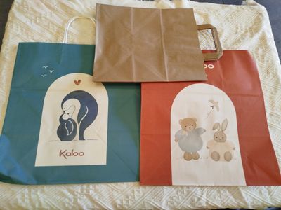 three bags with different designs on them on a bed