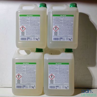 quatre bouteilles de liquide posées les unes à côté des autres sur un plan de travail