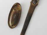 pair of antique spoons and spoon rest on a white surface