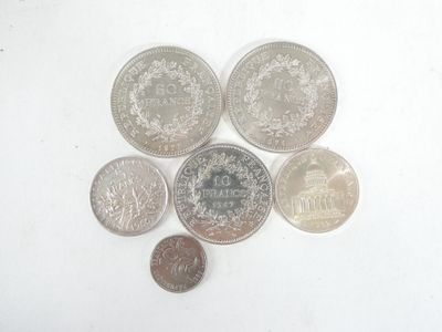 several different coins are arranged in a circle on a white surface