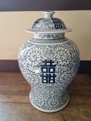 a blue and white vase with a lid sitting on a table
