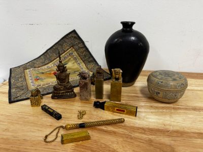 a wooden table topped with a black vase and other items