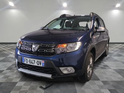 une photo d'une dacia bleue garée sur un sol en damier