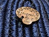 a close up of a blue hat with a gold button on it