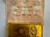 a gold bar sitting on top of a piece of paper