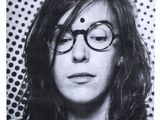 photographie en noir et blanc d'une femme portant des lunettes, sur fond à pois