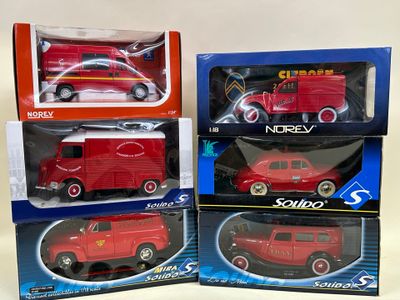 three red toy cars are in boxes on a white surface