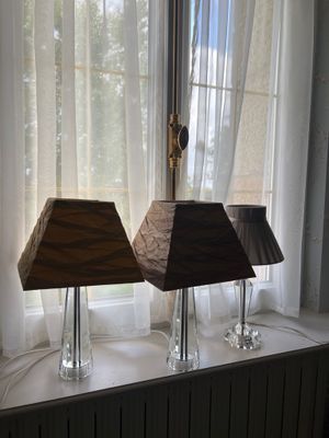 deux lampes posées sur le rebord d'une fenêtre, devant celle-ci