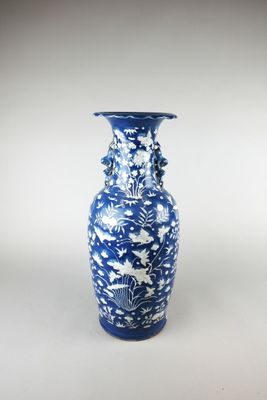 un vase bleu et blanc posé sur une surface blanche