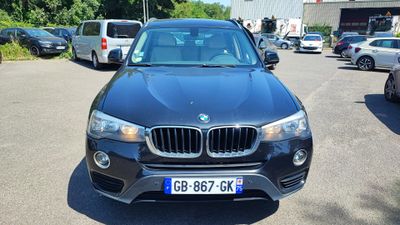 un SUV BMW noir garé sur un parking